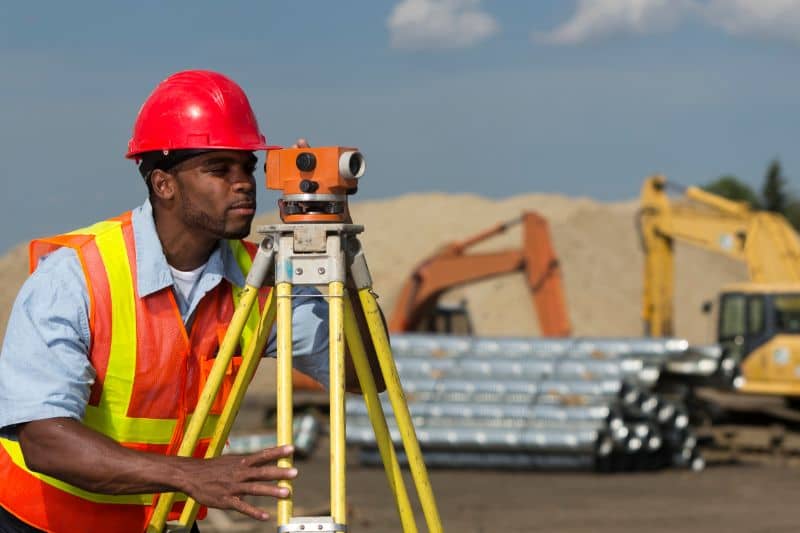 Land surveyor using a leveling instrument on a construction site in Ringgold, GA
