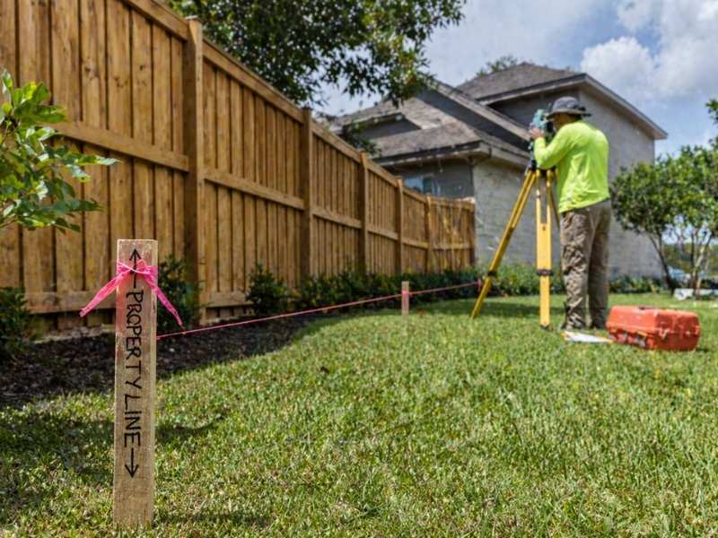 Property line survey for fence installation | Ringgold Land Surveying Property line survey being performed before fence installation with boundary markers and surveying equipment on a residential property